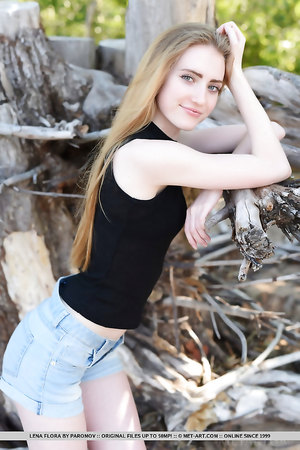 Small titted teen Lena Flora takes off her black shirt on the sand
