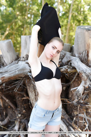 Small titted teen Lena Flora takes off her black shirt on the sand