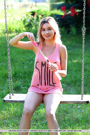 Angelina Ash undressing outdoors to spread her pussy on a swing